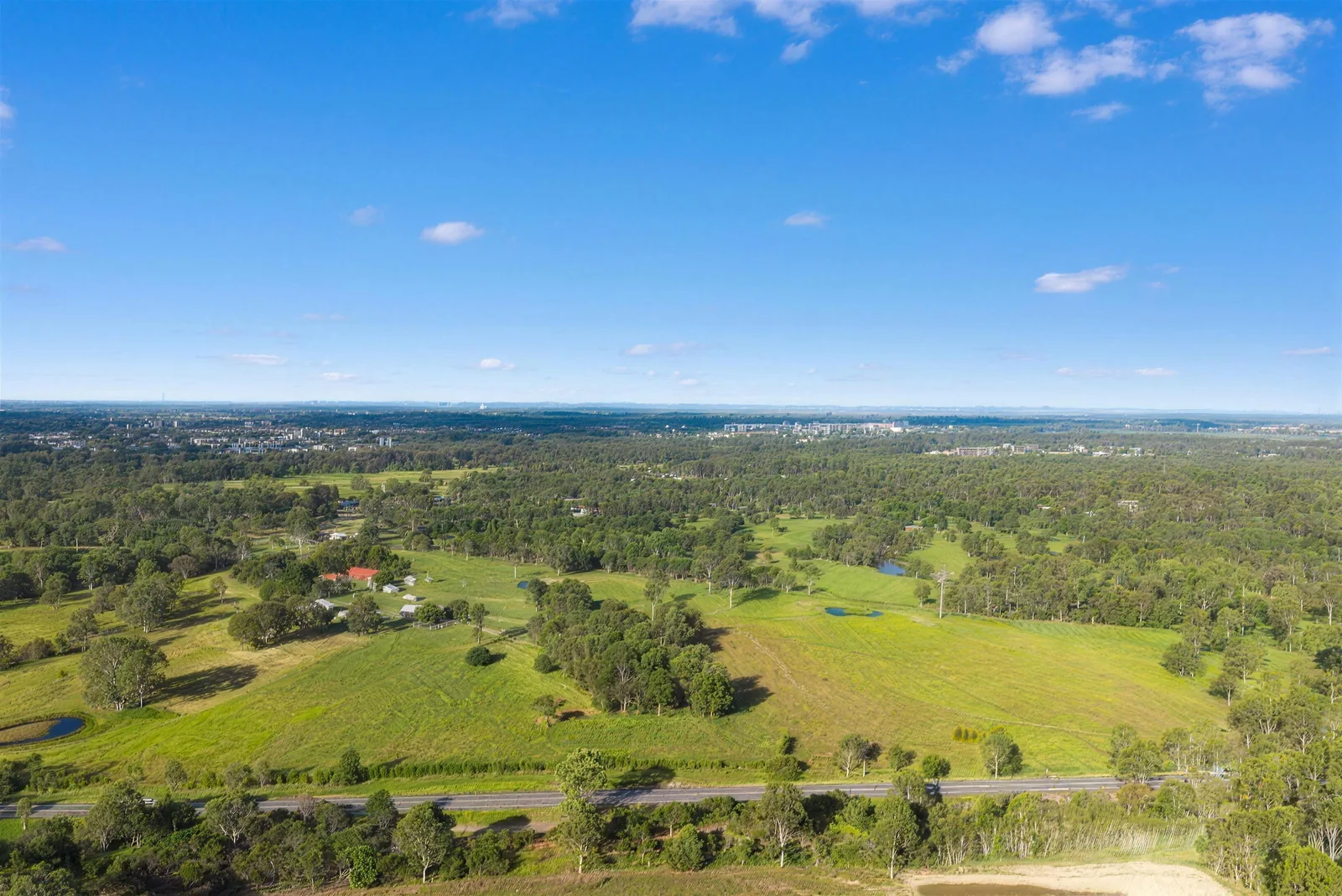 Aerial view of homes among trees with distant ranges near Maryborough