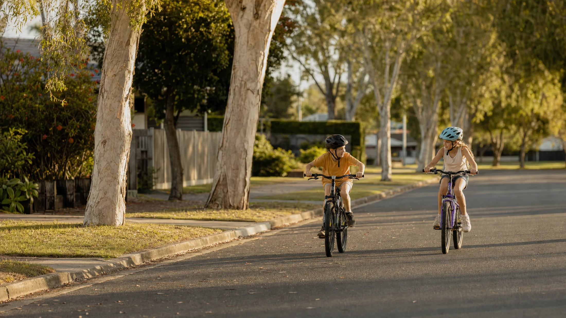 Children riding bikes on a quiet tree-lined street